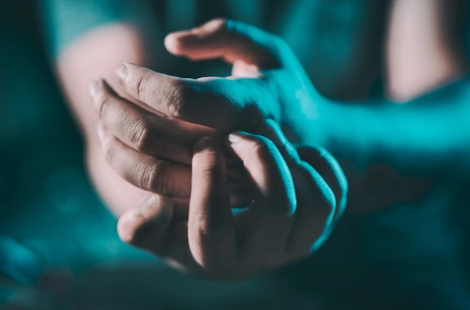 Hands clasped in dark light