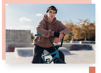 teen on BMX bike wearing hoodie in skatepark