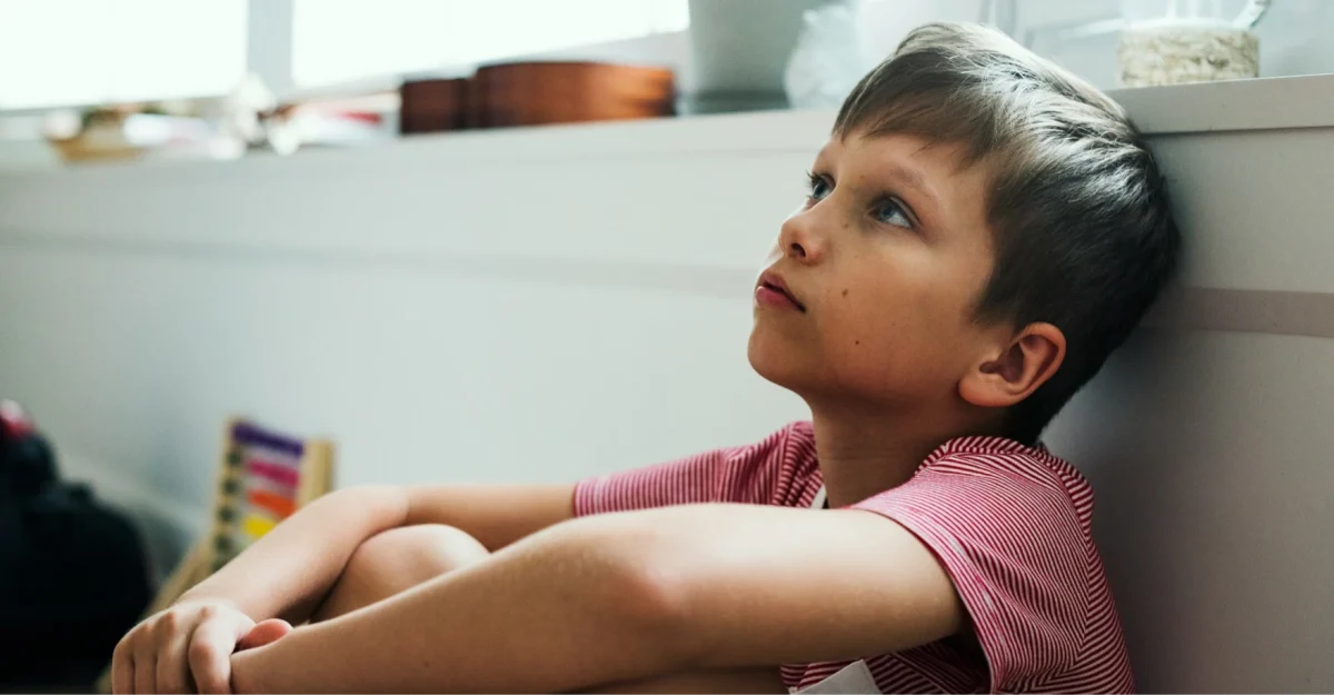 Boy-sat-against-wall-looking-up