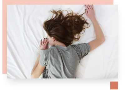 Girl crashed out over bed white sheets with brown hair scattered over shot from above