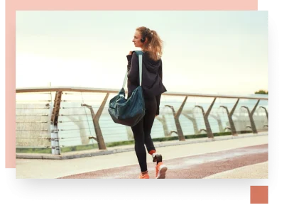 College teen with gym bag and headphones looking out over a modern bridge barrier