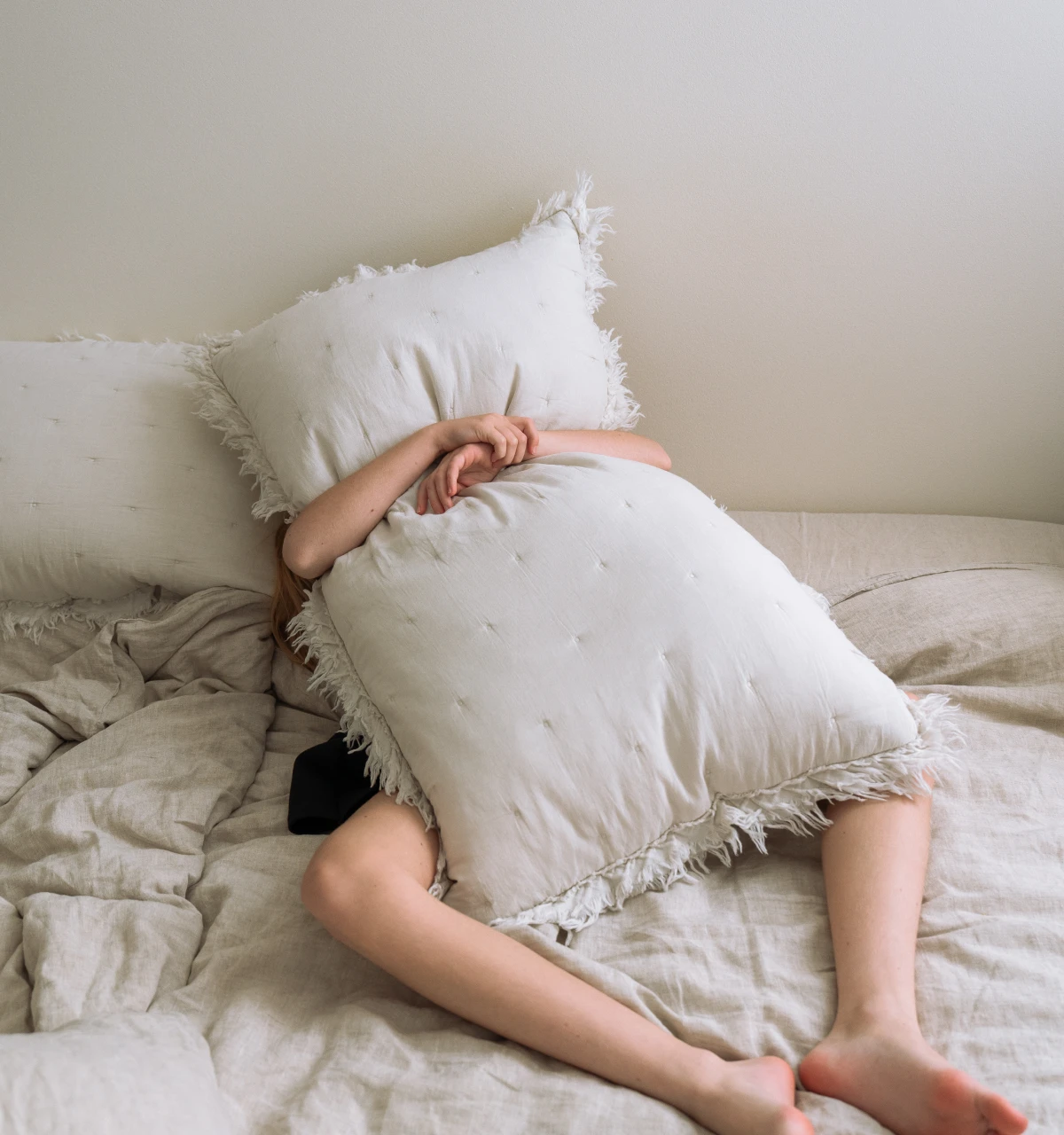 child-hiding-behind-pillow-in-frustration
