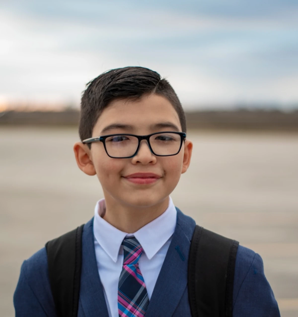 school-boy-with-glasses-outside-muted-background