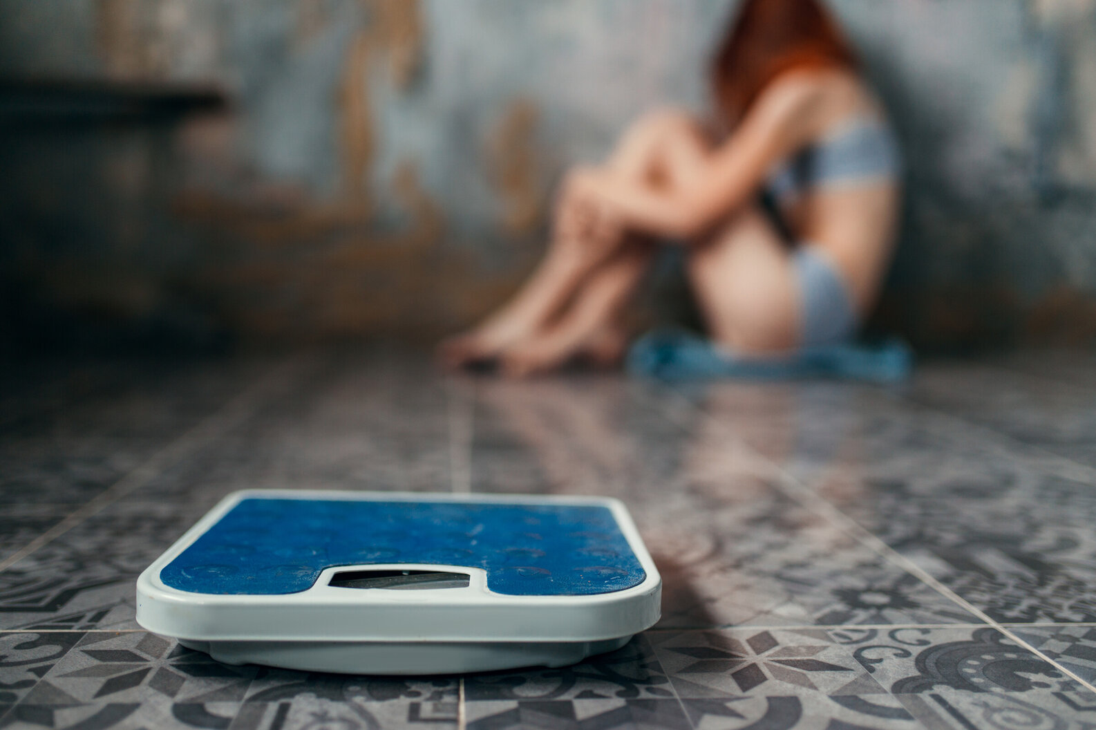 Young girl huddled in corner in distress