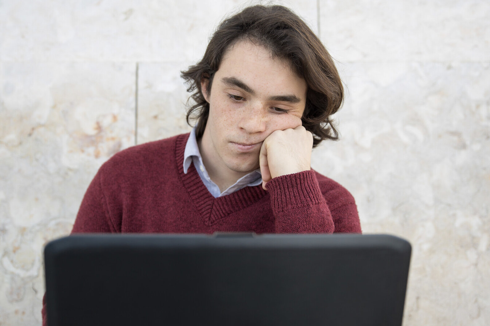 teen behind laptop watching screen