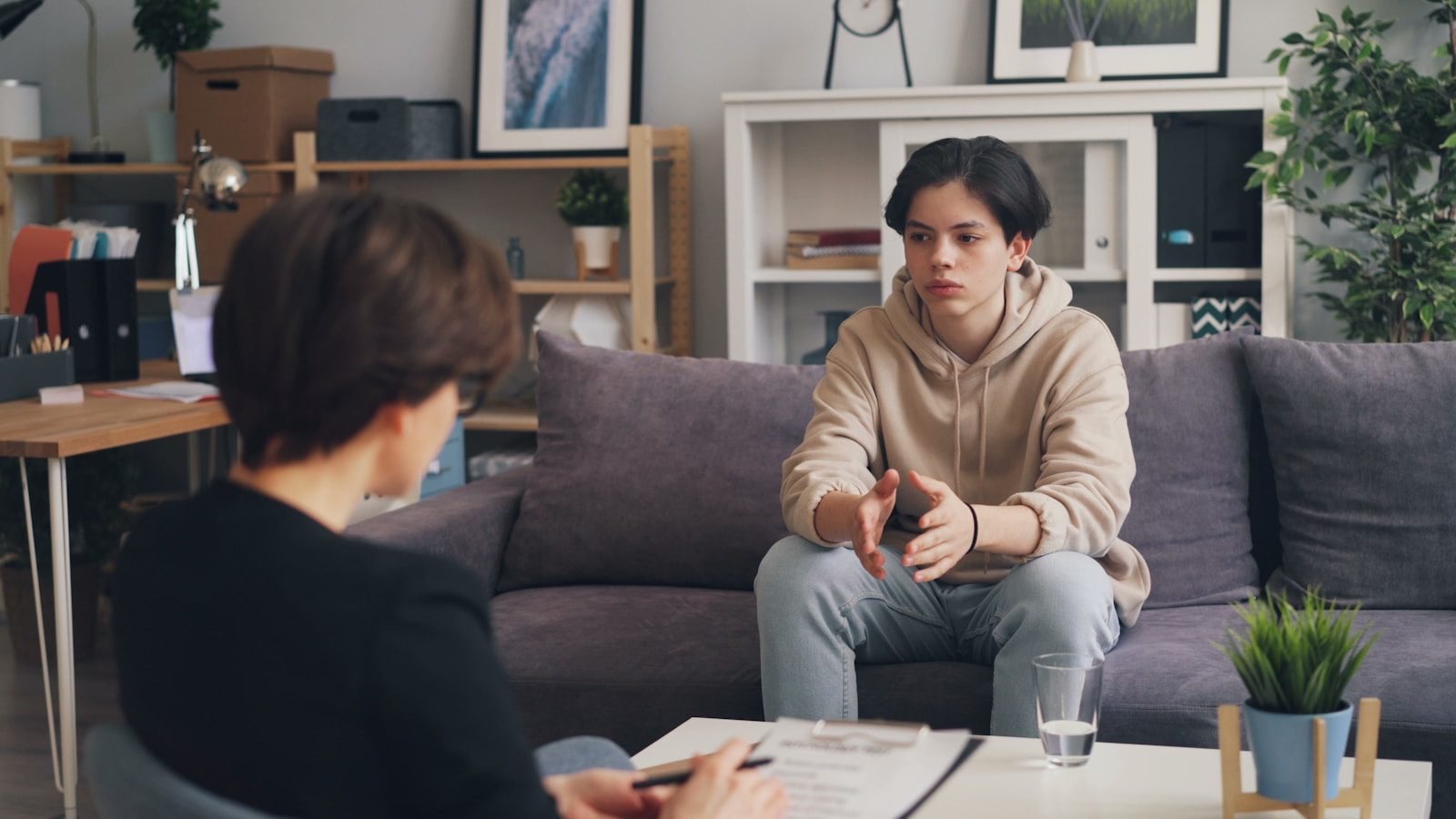 a woman sitting on a couch talking to a man